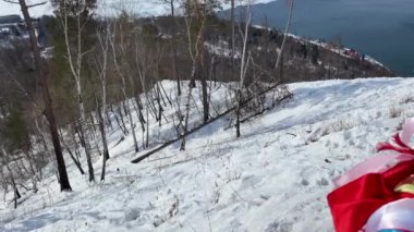Çok renkli Tibet Budist kurdeleleri rüzgarda savruluyor. Karla kaplı Baykal Gölü 'nün kuş bakışı manzaralı güzel bir manzarası. Donmayan Angara nehri Baykal 'a akar. Yukarıdan görüntüle.