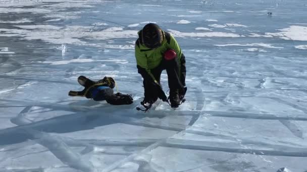 Man Grön Jacka Svart Hjälm Och Röda Knäskydd Sätter Skridskor — Stockvideo