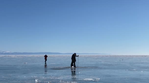 彼らは強さのために氷をテストしている 冷凍湖バイカルでの旅行 深い亀裂や雪の島と青透明氷と美しい冬の風景 — ストック動画