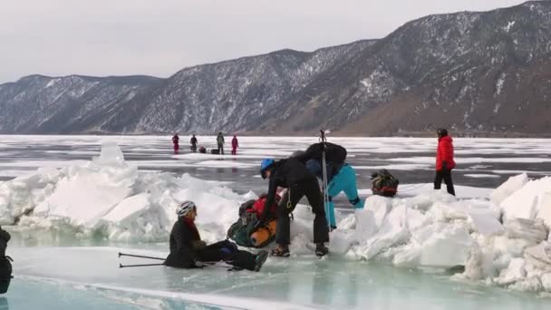 贝加尔 Irkutsk Region Russia 2021年3月14日 一群游客穿越小冰块 那女孩在冰上滑倒了 冻结的贝加尔湖 美丽的冬季风景 — 图库视频影像
