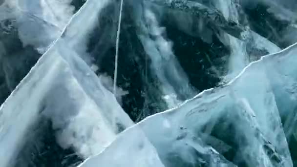 Velmi rychlé lyžování na zamrzlém jezeře Bajkal. Krásná zimní krajina s čistým, hladkým ledem. Modrý průhledný led s hlubokými prasklinami. Přírodní památka Ruska.