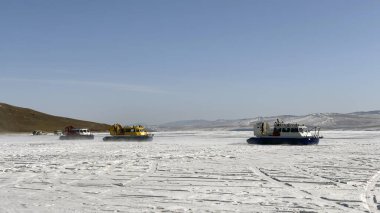 Donmuş Baykal Gölü 'nün buzunda, altında hava yastığı olan üç araba süzülüyor. Baykal Gölü 'nde güvenli ve rahat bir Khivus hoverkraft' ıyla dolaşın..