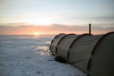 Donmuş karla kaplı Baykal Gölü üzerinde sobası olan büyük bir kış çadırı duruyor. Kış yürüyüşü. Kuzey manzarası. Rusya 'nın doğal simgesi.