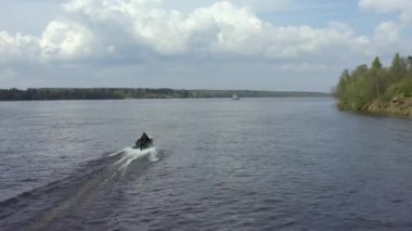 Helikopterin teknenin üstünde uçuşu. Bir balıkçı büyük güzel bir nehir boyunca bir teknede yelken açıyor..