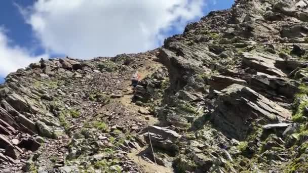 Een Wandelaar Met Een Grote Rugzak Gaat Langs Een Bergpad — Stockvideo