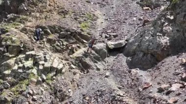 İri sırt çantalı iki dağcı yüksek bir dağdan iplere tutunarak iniyor. Kuzeyden, Rusya 'dan gelen Kazbek tırmanışı. Kafkasya 'da yürüyüş.