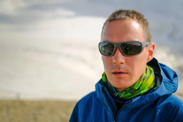 stock image Portrait of a man in mountain sunglasses. Tourist climber on the background of the mountain. Climbing Kazbek from the north, from the side of Russia. Hike across the Caucasus.