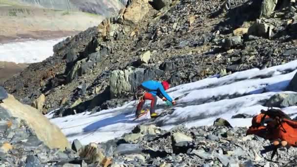 登山者が氷河から水を抽出している間 岩は山から落ちています 北からカズベク登山 ロシアから 素晴らしい山 岩や丘 — ストック動画