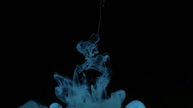 Siyah arkaplanda mavi-yeşil suluboya mürekkep. Mavi-yeşil mürekkep bulutu. Kozmik büyü geçmişi. Dalgalar ve mavi-yeşil renkler. Güzel soyut arkaplan.