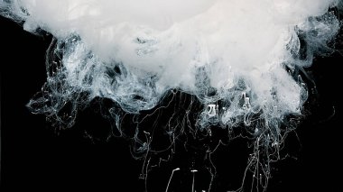 Güzel, beyaz, soyut bir arka plan. Siyah arka planda beyaz suluboya mürekkep. Sütlü mürekkep dalgaları ve suya beyaz boya damlaları..