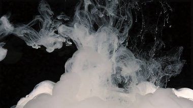 Yaratıcı beyaz soyut arka plan. Sütlü mürekkep dalgaları ve suya beyaz boya damlaları. Siyah arka planda beyaz suluboya mürekkep. Suya beyaz boya damlaları.