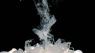 Kozmik büyü geçmişi. Beyaz mürekkep bulutu. Dalgalar ve beyaz boya damlaları. Beyaz soyut arka plan. Siyah arkaplanda beyaz suluboya mürekkep.