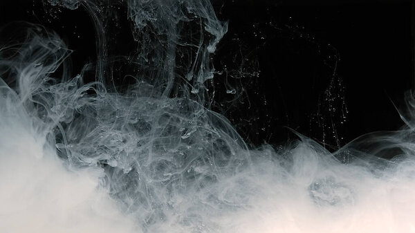 Fantastic white abstract background. White watercolor ink in water on a black background. Waves of milky ink and splashes of white paints in the water.