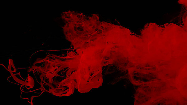 Awesome abstract background. Drops of red ink in water. Cosmic star background. Red watercolor paints in water on a black background. Beautiful wallpaper for your desktop. Red cloud of ink.