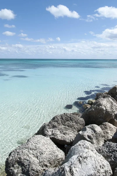 The wave breaker stones and crystal clear water on Freeport town Lucaya beach on Grand Bahama island.