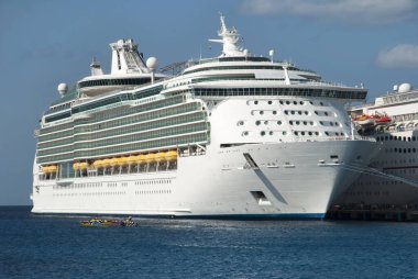 Cozumel Adası 'ndaki San Miguel' de demirlemiş büyük bir yolcu gemisinin yanından geçen bir yarış motoru.).