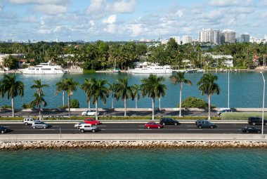 Arka planda MacArthur Causeway trafiği, yerleşim yeri Palm Island ve Miami Beach silueti (Florida). 