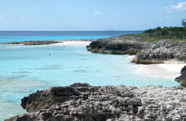 Half Moon Cay 'de kayalık bir sahil manzarası ve küçük kumlu plajlar sadece turistler için ıssız (Bahamalar).