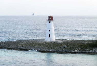 Cennet Adası deniz fenerinin arka planda bir yolcu gemisiyle sabah erken saatlerde görüntüsü (Nassau, Bahamalar).
