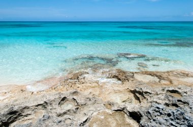 Yarım Ay 'ın kayalık kıyı manzarası ve turkuaz rengi şeffaf sular (Bahamalar)).