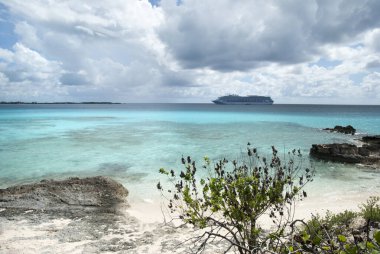 Yarım Ay Cay kayalık plajı arka planda sürüklenen bir yolcu gemisi (Bahamalar)).