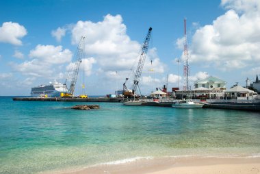 Büyük Cayman Adaları 'nda (Cayman Adaları) arka planda yolcu gemileri bulunan George Town limanı yakınlarındaki bir halk plajı manzarası).