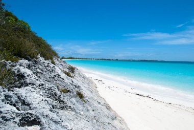 The scenic view of an empty beach along the rocky coastline on Half Moon Cay (Bahamas).