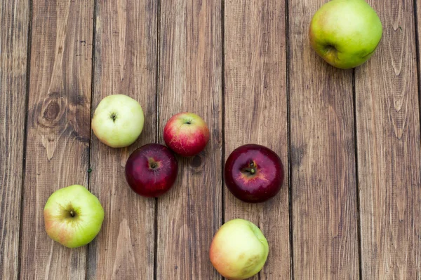 Algunas manzanas sobre un fondo de madera — Foto de Stock