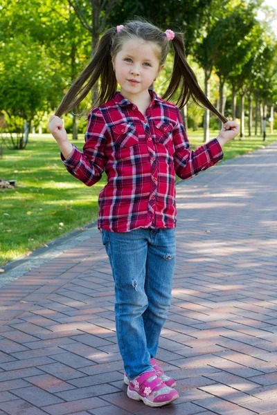 Girl with pigtails in jeans — Stock Photo, Image