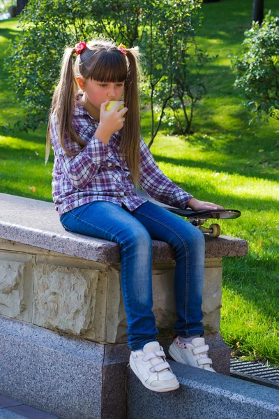 Girl with an apple in jeans — Stock Photo, Image