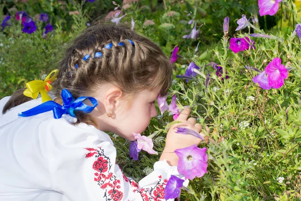 Little girl smelling flowers — Stock Photo, Image