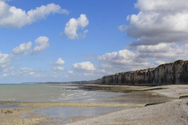 Büyük beyaz kayalıklar deniz boyunca ve yazın Fransa 'nın Normandiya sahillerinde beyaz bulutlu mavi gökyüzü