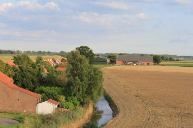 Zeeland 'de tipik bir Alman kırsal arazisi. Westerschelde' in deniz duvarının arkasında küçük eski bir köy. Tarım arazilerinin yanında yaz aylarında hendek var.