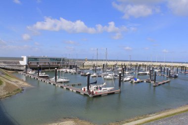 Cadzand 'daki Hollanda sahilindeki yat, balıkçı teknesi, restoran ve açık mavi gökyüzü olan marina.