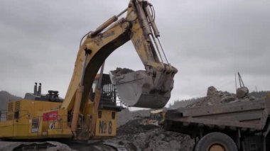 Yuzhno-Sakhalinsk, 1 Temmuz 2021. Komatsu PC2000 kazıcı cevheri Komatsu HD785 damperli kamyona yüklüyor.