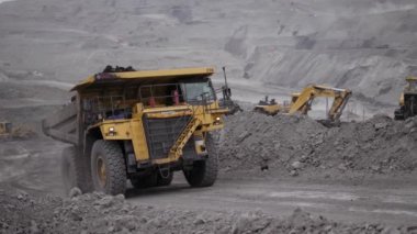 Yuzhno-Sakhalinsk, 1 Temmuz 2021. Dolu bir Komatsu HD785 damperli kamyon açık bir çukura giriyor. Arka planda, taş ocağını ve maden ekipmanlarını iş başında görebilirsiniz..