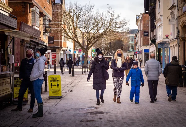 Soğuk bir kış gününde Canterbury High Caddesi 'nde maskeli ve sosyal mesafeli insanlar..