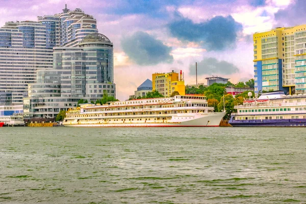 Binaların arka planında büyük beyaz bir gemi. 