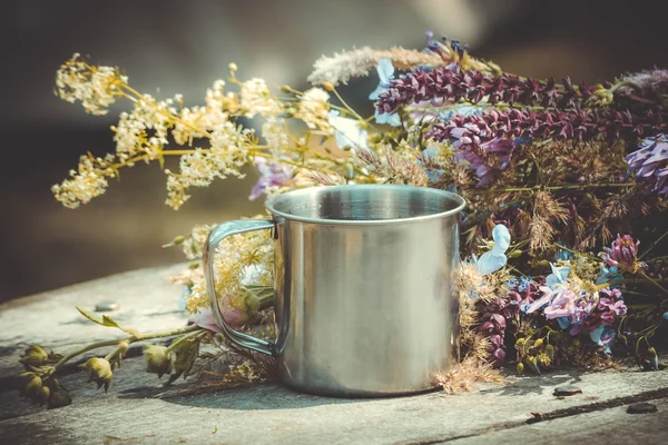 Bouquet of spring flowers and a cup on the table — Stock Photo, Image