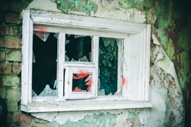 Eski bir pencere çerçevesi içinde kırık cam