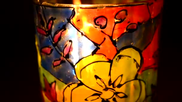 Candle flame shines in a colorful candlestick — Stock Video