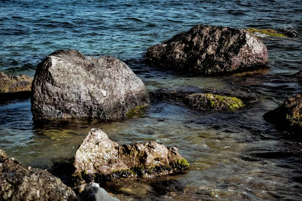 Einige Felsen in Ufernähe im Wasser — Stockfoto