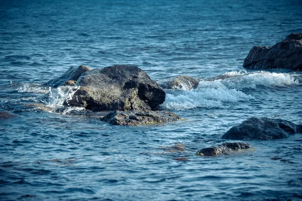 Fondo enormes rocas en el mar cerca de la orilla — Foto de Stock