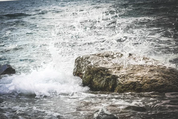 Salpicadura de agua en una roca en el mar — Foto de Stock