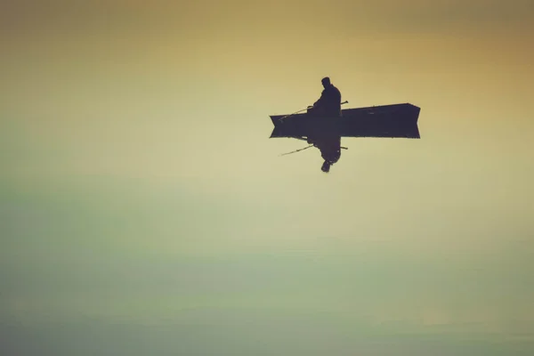 Fischer im Boot mit Spiegelung, verspiegeltes Wasser — Stockfoto