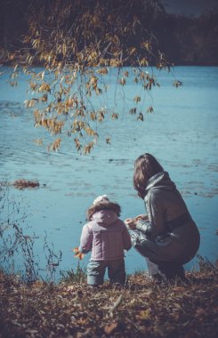 kadın ve küçük çocuk sonbahar Nehri kıyısında
