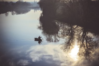 nehir bir siluet balıkçı tekne yelken görüntülemek
