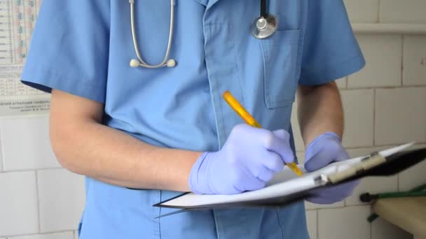Doctor escribe en el papel en sus manos — Vídeo de stock