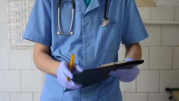 Doctor writes on paper in his hands — Stock Video