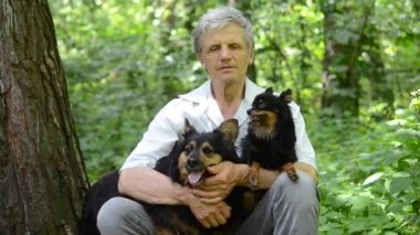portre yaşlı adam ormanda köpeklerle